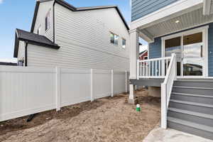 View of side of home featuring a wooden deck and stairs