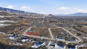 Snowy aerial view featuring a mountain view and a residential view