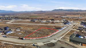 Aerial view of residential area featuring a mountainous background and property boundaries highlighted