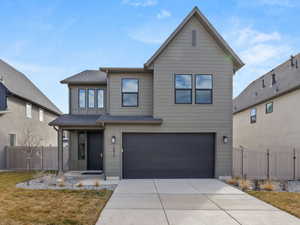 Traditional home featuring a gate, an attached garage, and driveway