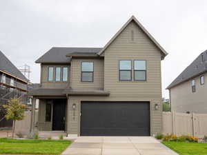 View of front facade with a gate, an attached garage, and concrete driveway
