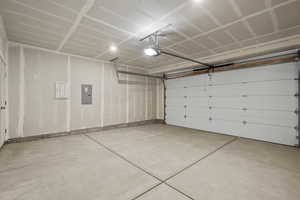 Garage with electric panel and a garage door opener