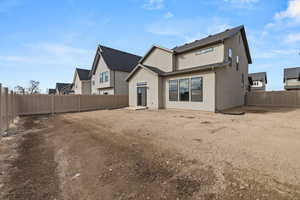Rear view of house featuring a fenced backyard, stucco siding, and a residential view