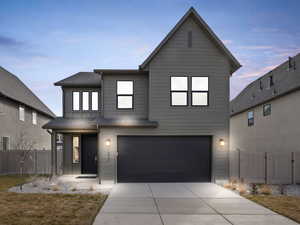 View of front of property featuring a gate, an attached garage, and driveway