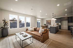 Living area featuring light wood-style floors and recessed lighting