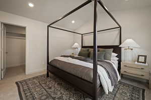 Carpeted bedroom featuring a spacious closet, vaulted ceiling, and recessed lighting