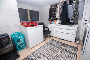 Laundry room with washer / clothes dryer and light tile patterned floors