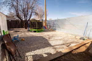 Fenced backyard with a trampoline