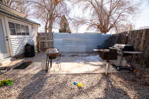 Fenced backyard featuring a patio area and grilling area
