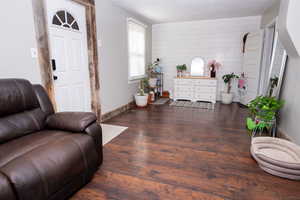 Living area with wood walls and dark wood finished floors