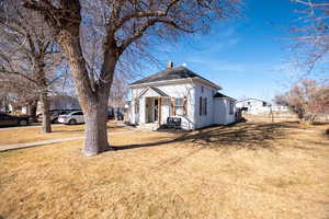 View of front of property with a chimney and a front yard