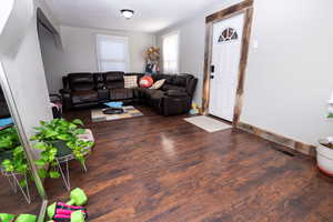 Living area with dark wood-style floors and baseboards