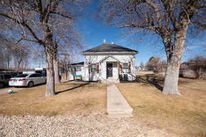 View of front facade with a front yard and a chimney