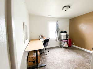 Office space with light carpet and baseboards