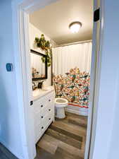 Bathroom featuring vanity, dark wood-style floors, and shower / tub combo