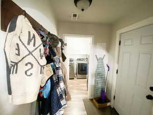 Mudroom with light wood-type flooring and washing machine and dryer