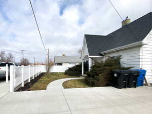 View of home's exterior with a shingled roof and a chimney