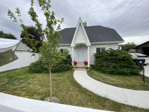 White vinyl siding residence with a prominent front-facing gable, dark shingle roof, and a covered entry porch