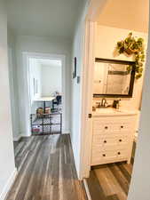 Corridor with dark wood-style flooring and a sink