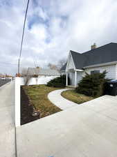 View of side of property with a shingled roof and a chimney