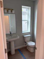 Half bathroom with toilet and light wood-style floors