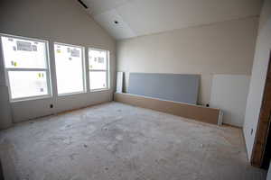 Unfurnished room featuring lofted ceiling