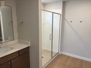 Bathroom featuring a stall shower, vanity, and light wood finished floors