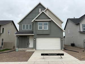 View of front of property featuring concrete driveway, a garage, board and batten siding, and covered porch