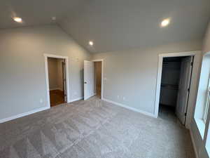 Unfurnished bedroom with a walk in closet, recessed lighting, and light carpet