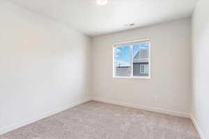 Unfurnished room featuring baseboards and light carpet