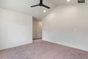 Carpeted empty room featuring lofted ceiling, recessed lighting, and a ceiling fan