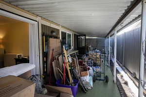 Large covered patio with flowerbed.  Please pardon the moving process.