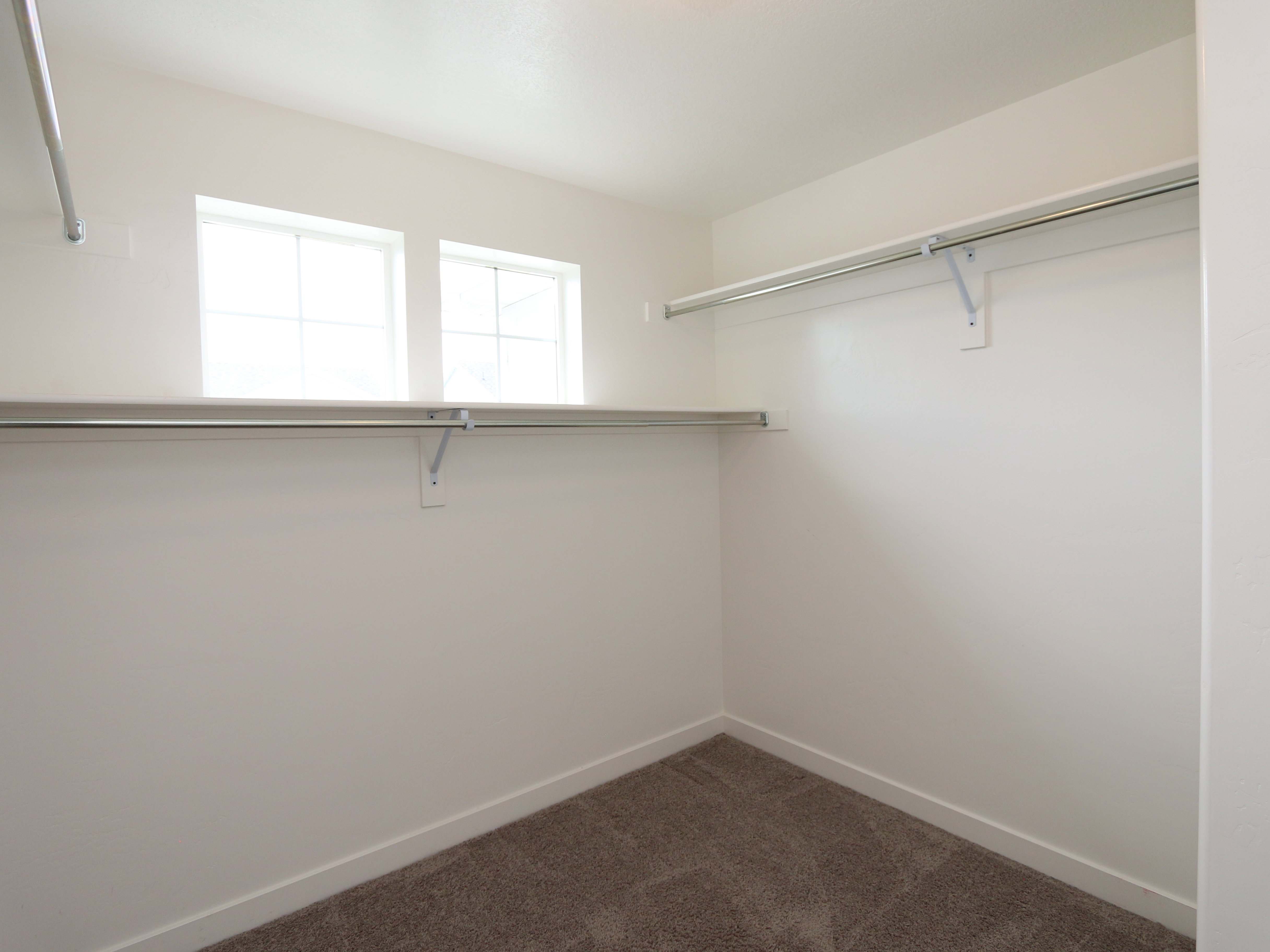 Walk in closet with dark colored carpet