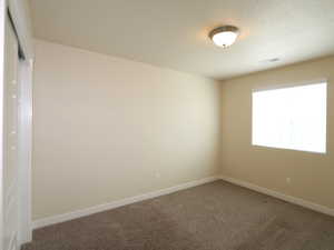Empty room with carpet flooring and baseboards