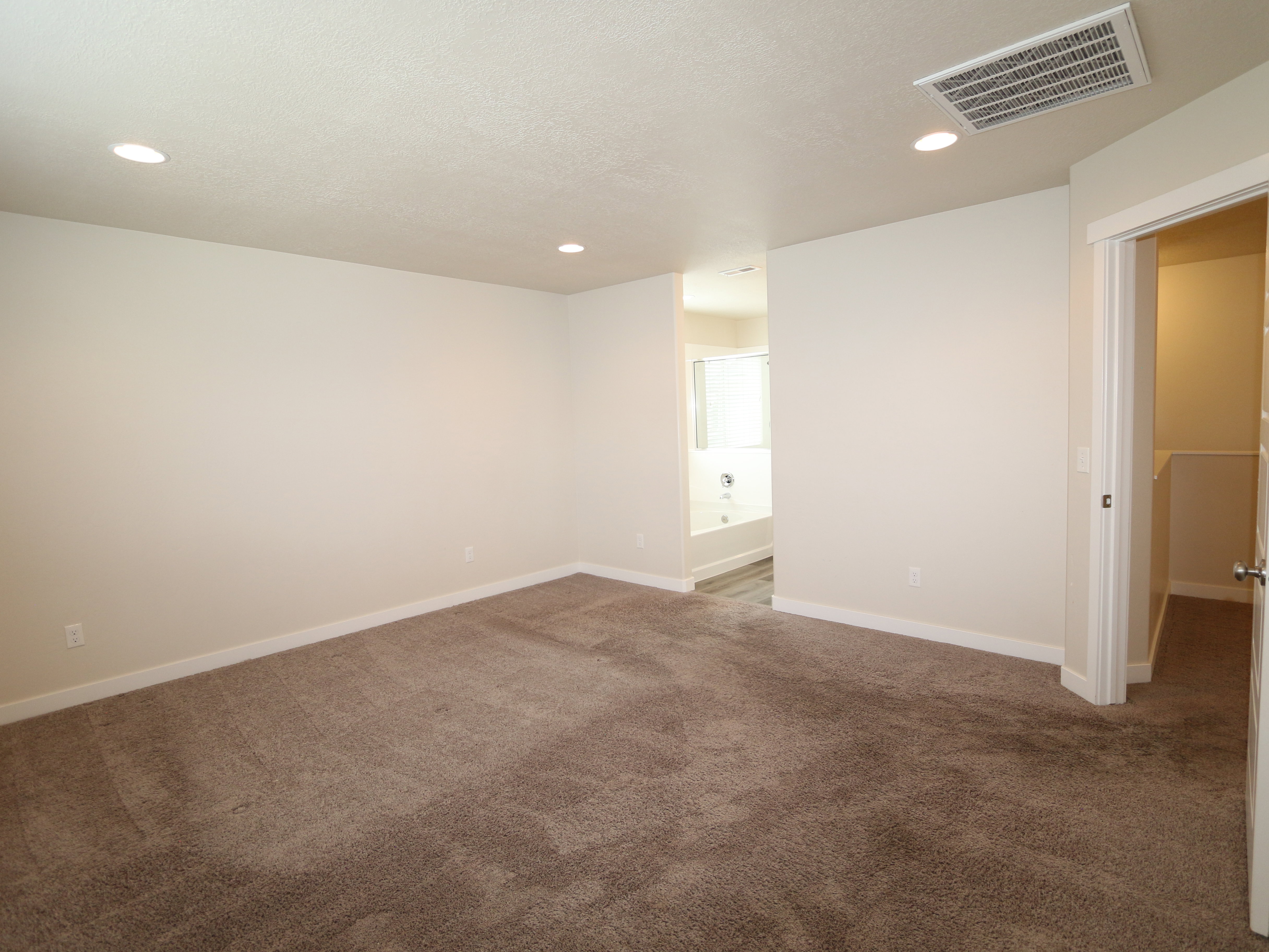 Spare room with dark colored carpet and recessed lighting