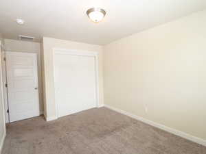 Unfurnished bedroom featuring a closet and carpet flooring