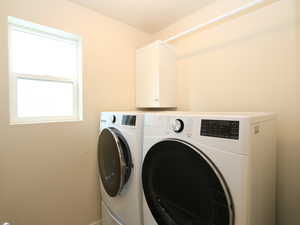 Laundry room featuring separate washer and dryer and cabinet space