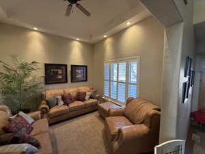 Carpeted living area featuring a textured wall, ceiling fan, and recessed lighting