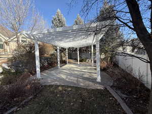Fenced backyard featuring a pergola and a patio area