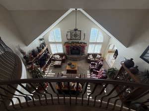 Living area with carpet flooring, a fireplace, vaulted ceiling, and plenty of natural light