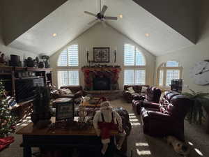 Carpeted living room with a high textured ceiling, a fireplace, recessed lighting, and ceiling fan