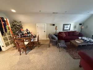 Living room featuring light colored carpet, vaulted ceiling, and recessed lighting
