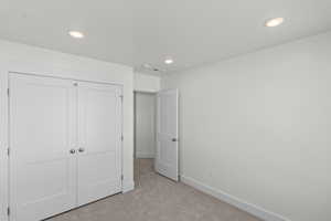 Unfurnished bedroom with carpet floors, a closet, and recessed lighting