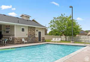 Community pool featuring a patio area and a fenced backyard