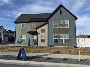 View of front of property with brick siding and a standing seam roof