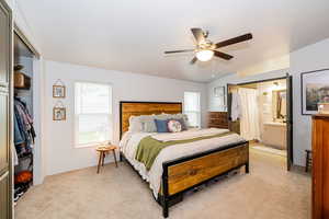 Bedroom featuring a closet, multiple windows, light colored carpet, and lofted ceiling