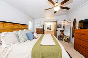 Bedroom featuring ensuite bathroom, carpet flooring, ceiling fan, and lofted ceiling