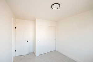 Unfurnished bedroom with carpet and a closet