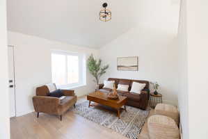Living room featuring light wood-style floors and vaulted ceiling