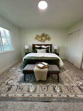 Carpeted bedroom with baseboards and a closet